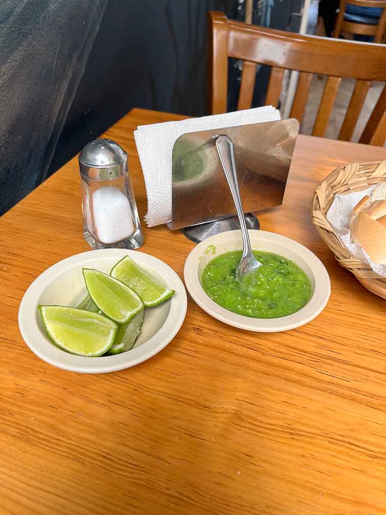 Extras: photo showing limes, salsa, salt and bread. Affordable restaurants in Mexico.
